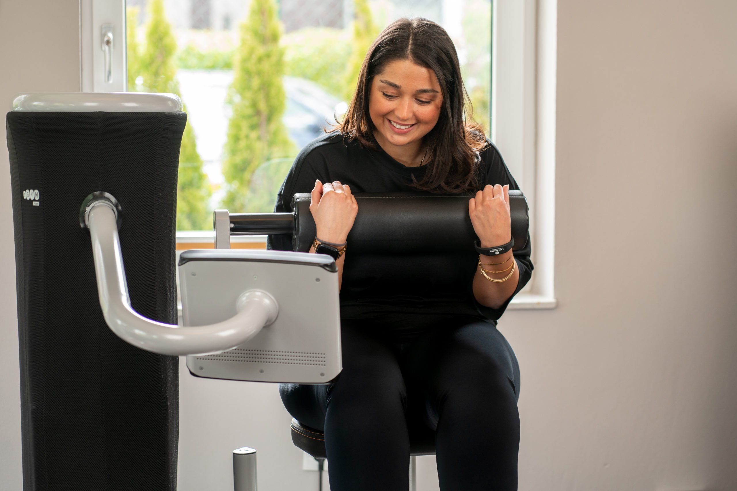 Freude an Bewegung: Eine Teilnehmerin nutzt moderne Fitnessgeräte in einem hellen, freundlichen Trainingsraum im LADY Fitness Oldenburg.